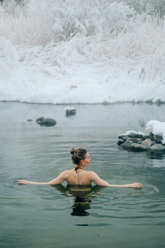 Back of a Young Woman Bathing in a Winter Lake